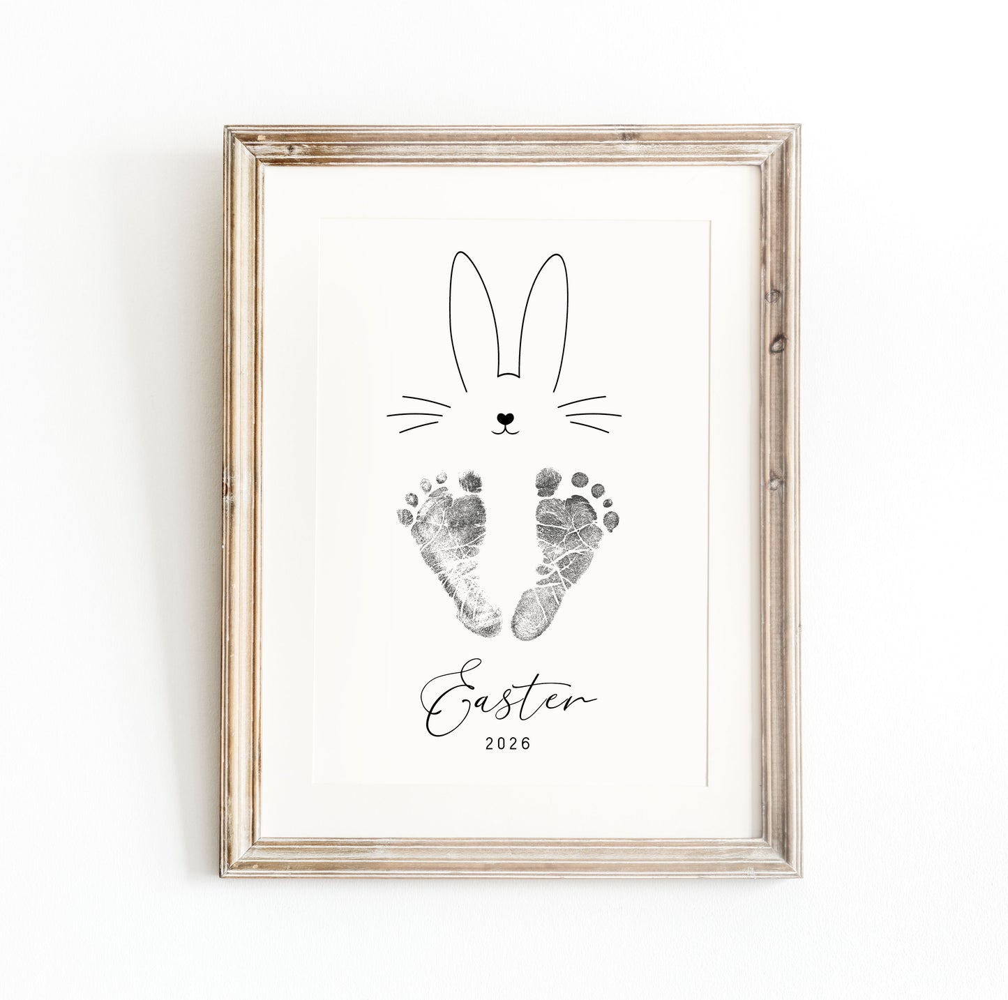 Framed keepsake with a bunny design, baby's footprints and 'Easter 2026' text on a white background
