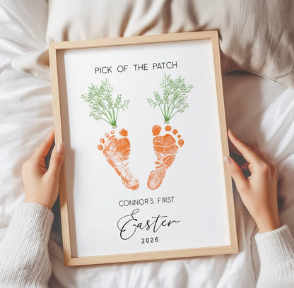 Framed keepsake with footprints and text held by hands on a soft surface