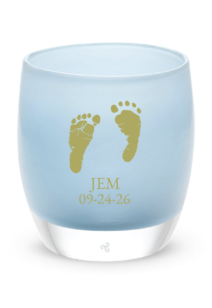 Glassybaby tea light holder with gold footprints and text on a white background