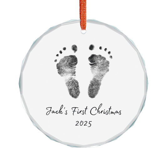 Round glass ornament with personalized baby footprints and 'First Christmas 2025' text on a white background.