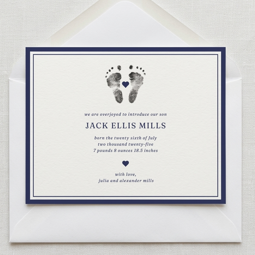 Newborn baby announcement card with footprints and text on a white background