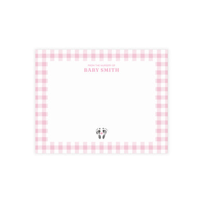 Pink gingham border with baby footprints and text on a white background