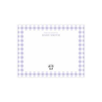 Purple gingham border with baby footprints and text on a white card.